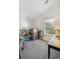 Bright bedroom features a window view, neutral carpet, and vaulted ceiling at 701 Harlan St # E29, Lakewood, CO 80214