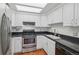 Clean kitchen with white cabinets, black countertops, and stainless steel appliances at 701 Harlan St # E29, Lakewood, CO 80214