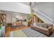 Spacious living room with hardwood floors, white staircase, and open layout to kitchen at 701 Harlan St # E29, Lakewood, CO 80214