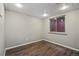 Basement room with hardwood floors, painted walls, and a window at 7476 E Arkansas Ave # 1-03, Denver, CO 80231