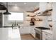 Stylish kitchen featuring stainless steel appliances, an island, and floating shelves with lighting at 11229 Running Kit Pl, Franktown, CO 80116