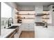 Bright kitchen with modern stainless steel appliances, open shelving, and a farmhouse sink at 11229 Running Kit Pl, Franktown, CO 80116