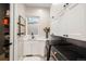 Well-organized laundry room with white cabinets, quartz countertop, matte black hardware, and modern washer/dryer at 11229 Running Kit Pl, Franktown, CO 80116