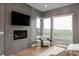 Modern living room with an electric fireplace, comfortable chair, and lots of natural light from large windows at 11229 Running Kit Pl, Franktown, CO 80116