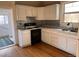 Bright kitchen featuring white cabinetry and a vintage tile backsplash at 3890 N Wolff St, Denver, CO 80212