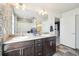 Bathroom featuring double sinks, a large mirror, and neutral decor at 7117 Frying Pan Dr, Frederick, CO 80530