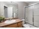 This bathroom has a shower with glass door, a nice mirror and a sink with a cabinet for storage at 13906 Jackson St, Thornton, CO 80602