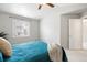 This bedroom has a large window, a ceiling fan, a soft bed and neutral walls and carpeted floors at 13906 Jackson St, Thornton, CO 80602