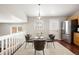 Bright dining area with a modern glass table and four chairs, complemented by an elegant light fixture at 13906 Jackson St, Thornton, CO 80602