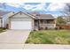 Charming home featuring a two-car garage, stone accents, and a cozy front porch, complemented by a well-manicured lawn at 13906 Jackson St, Thornton, CO 80602