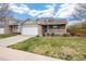 A well-maintained home with a two-car garage, attractive stone facade, and a quaint front porch, set on a green lawn at 13906 Jackson St, Thornton, CO 80602