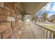 Covered front porch with stone detailing, providing a cozy outdoor space and neighborhood views at 13906 Jackson St, Thornton, CO 80602