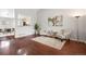 Open concept living room featuring hardwood floors, stylish furnishings, and seamless flow to dining at 13906 Jackson St, Thornton, CO 80602
