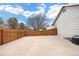 Expansive concrete patio area with a wooden fence, offering ample space for outdoor furniture and entertaining guests at 13906 Jackson St, Thornton, CO 80602
