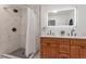 Modern bathroom with a double vanity and backlit mirror, a shower stall, and attractive black-and-white tile at 1326 Sable Blvd, Aurora, CO 80011