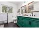 Well-lit bathroom features a dual sink vanity, stylish mirror, and hexagon flooring at 2658 W 1St Ave, Denver, CO 80219