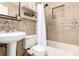Well-lit bathroom with modern fixtures, stylish tile work, and open shelving, enhancing the room's functionality at 2658 W 1St Ave, Denver, CO 80219