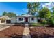 Charming single-story home featuring a red door, manicured lawn, and a concrete pathway at 2658 W 1St Ave, Denver, CO 80219