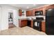 Kitchen with cherry cabinets, black appliances, tile floors, and a view to the laundry room at 2658 W 1St Ave, Denver, CO 80219