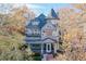 Elegant gray home showcasing a turret, detailed roofline, and inviting front porch framed by trees at 1459 N Pennsylvania St # B, Denver, CO 80203