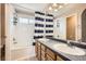 Well-lit bathroom with double sink vanity, a toilet, and a bathtub-shower combination at 9882 Harris St, Thornton, CO 80229