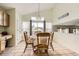 Bright dining area with a table set for four, next to a large window at 9882 Harris St, Thornton, CO 80229