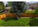 Spacious backyard with a well-maintained lawn, bordered by a wooden fence and mature trees, offering privacy at 12498 W Prentice Dr, Littleton, CO 80127