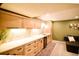 Basement bar with modern countertops, stylish backsplash, and seating area at 12498 W Prentice Dr, Littleton, CO 80127