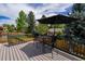 Outdoor deck featuring an umbrella-covered table and chairs, perfect for enjoying the backyard view on sunny days at 12498 W Prentice Dr, Littleton, CO 80127