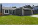 Inviting home featuring green siding, brick accents, and a well-maintained front yard at 12498 W Prentice Dr, Littleton, CO 80127