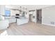 Open concept kitchen with modern appliances, island, hanging lights and gray backsplash at 2078 S Holly St # 1, Denver, CO 80222