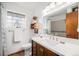Bright bathroom featuring a spacious countertop, wood cabinets, and a large framed mirror at 7930 Quitman St, Westminster, CO 80030