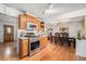 Open kitchen with modern appliances, wood cabinets, hardwood floors, and a dining area in the background at 7930 Quitman St, Westminster, CO 80030