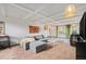 Bright living room featuring a gray sectional couch, beamed ceiling, and large windows providing natural light at 7930 Quitman St, Westminster, CO 80030