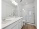 Bathroom with double vanity, quartz countertop, white cabinetry and glass shower doors at 6615 N Nepal St, Aurora, CO 80019