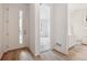 Bright entryway with wood-look floors, leading to a living area and a half bathroom at 6615 N Nepal St, Aurora, CO 80019