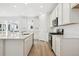 An open kitchen with an island, sleek countertops, stainless appliances and modern white cabinetry at 6615 N Nepal St, Aurora, CO 80019