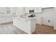 Bright kitchen featuring an island with light countertops, modern appliances and light flooring at 6615 N Nepal St, Aurora, CO 80019