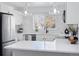 Modern white kitchen with stainless steel appliances and marble backsplash at 1130 Oak Pl, Thornton, CO 80229