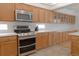 Modern kitchen with stainless steel appliances and wood cabinets at 19877 E 40Th Ave, Denver, CO 80249