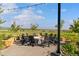 Community fire pit area with chairs, stone surround, landscaping, and views of the surrounding green spaces at 11103 Cloud Shadow St, Littleton, CO 80125