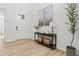 Bright foyer features light wood floors, neutral walls, console table with decor, and a view of the front door at 11103 Cloud Shadow St, Littleton, CO 80125