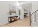Spacious foyer with wood floors, neutral walls, console table with decor, and a view of the staircase and kitchen at 11103 Cloud Shadow St, Littleton, CO 80125