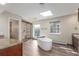 Bright bathroom featuring skylight, shower, and soaking tub at 3577 S Hillcrest Dr, Denver, CO 80237