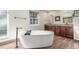Bright bathroom featuring soaking tub and dual sinks with dark wood cabinetry at 3577 S Hillcrest Dr, Denver, CO 80237