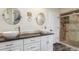 Bathroom featuring dual vessel sinks, dark countertop, and a glass enclosed shower at 3577 S Hillcrest Dr, Denver, CO 80237