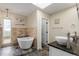 Bathroom with double sinks, a modern bathtub, tiled walls, and a skylight providing natural light at 3577 S Hillcrest Dr, Denver, CO 80237