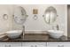 Bathroom featuring double sinks, stylish fixtures, a dark countertop, and decorative oval mirrors at 3577 S Hillcrest Dr, Denver, CO 80237