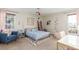 Bright bedroom featuring a comfortable bed, cozy chair, stylish decor, and natural light from two windows at 3577 S Hillcrest Dr, Denver, CO 80237
