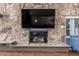 Close-up of the fireplace, featuring a stone surround and wood beam mantle at 3577 S Hillcrest Dr, Denver, CO 80237